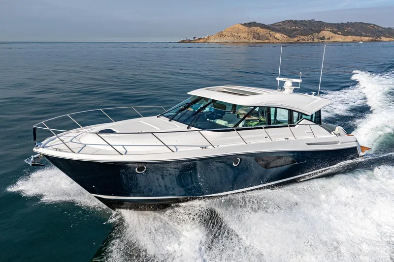 Slide: The Image of 2021 Tiara Yachts 53 Coupe cruising on open water, showcasing sleek design and luxury. - 13