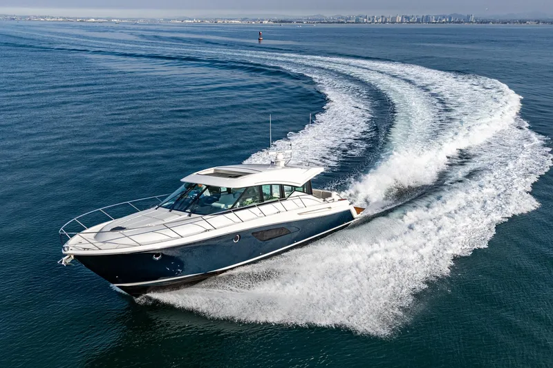 Slide: The Image of 2021 Tiara Yachts 53 Coupe cruising on open water, creating a dynamic wake. - 15