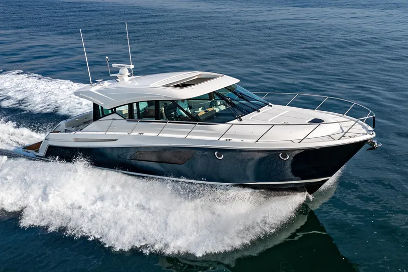 Slide: The Image of 2021 Tiara Yachts 53 Coupe cruising on open water, showcasing sleek design and performance. - 17