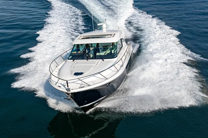 Slide: The Image of 2021 Tiara Yachts 53 Coupe cruising on open water, showcasing sleek design and powerful performance. - 20