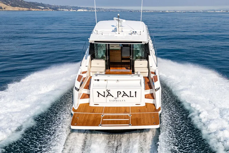 Slide: The Image of 2021 Tiara Yachts 53 Coupe cruising on open water, rear view. - 26