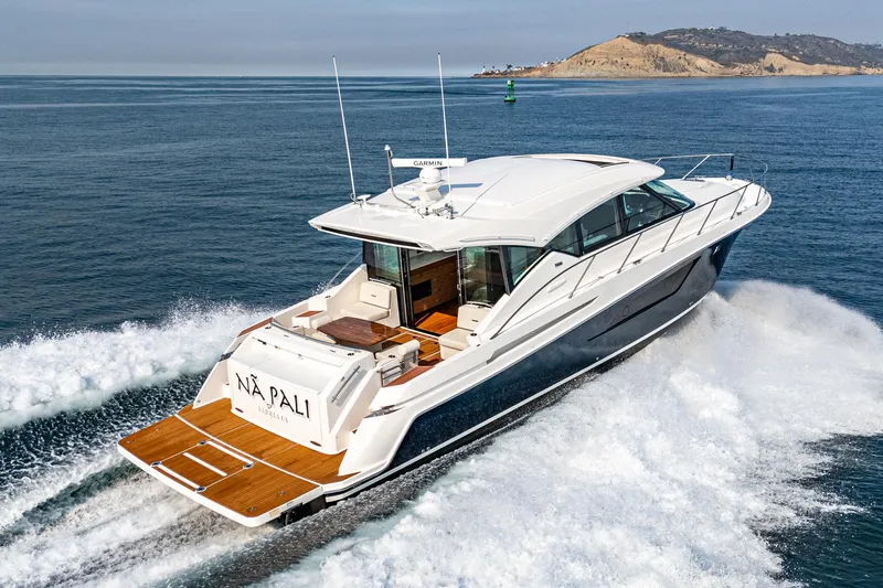 Slide: The Image of 2021 Tiara Yachts 53 Coupe cruising on open water near a coastal landscape. - 27