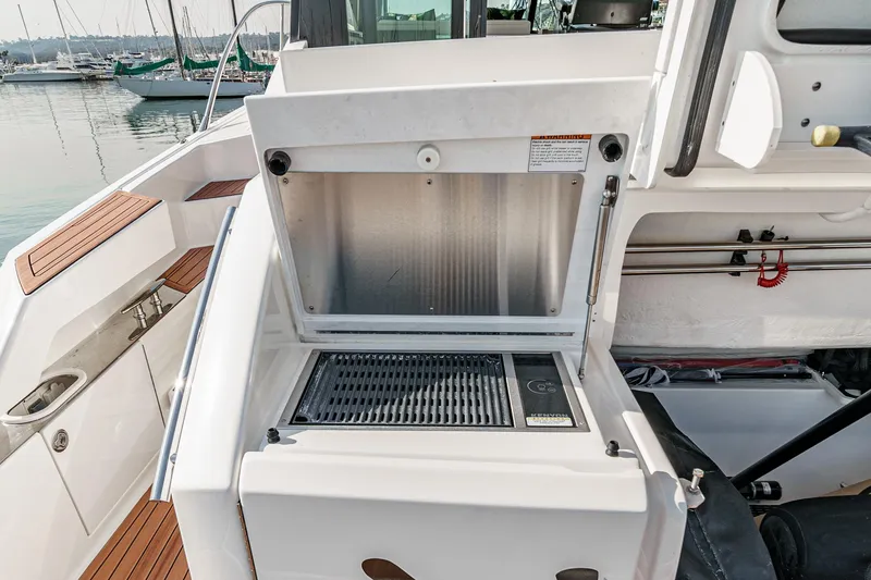 Slide: The Image of 2021 Tiara Yachts 53 Coupe outdoor grill on deck with marina view. - 30