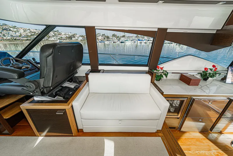 Slide: The Image of Interior of 2021 Tiara Yachts 53 Coupe with white seating and scenic window view. - 51