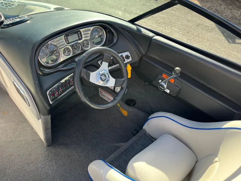 Slide: The Image of 2010 Malibu 21 vRide boat interior with steering wheel and dashboard controls. - 12