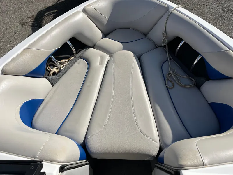 Slide: The Image of 2010 Malibu 21 vRide boat interior with gray and blue cushioned seating. - 14