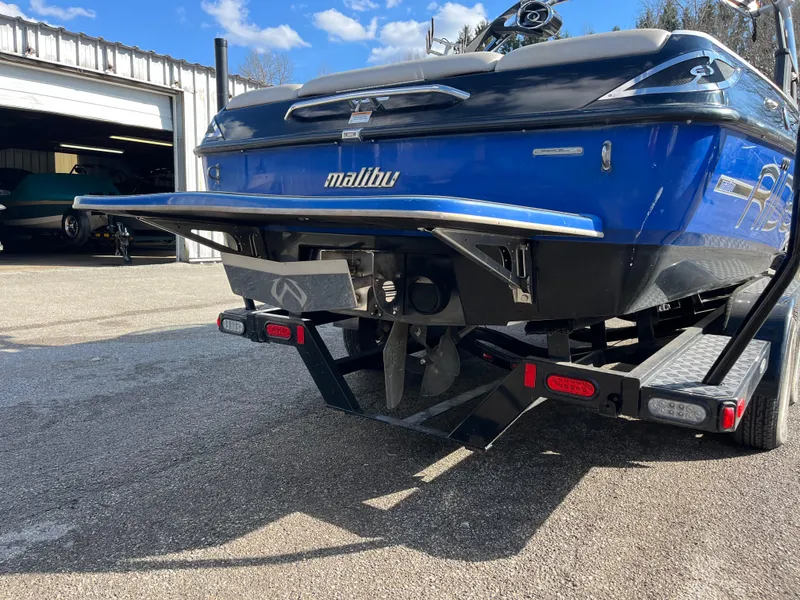 Slide: The Image of 2010 Malibu 21 vRide boat on trailer, rear view, blue and black color scheme. - 4