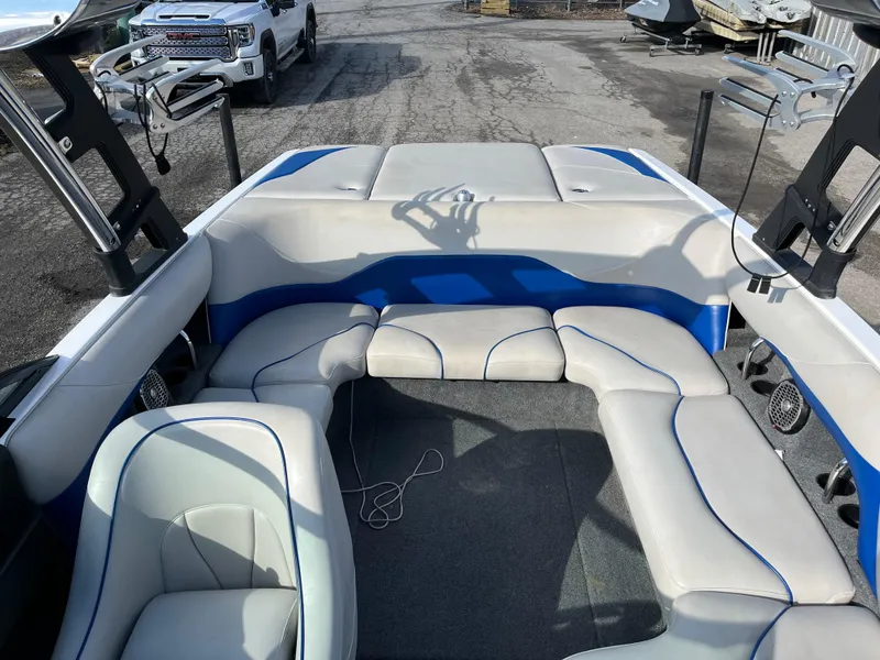 Slide: The Image of 2010 Malibu 21 vRide boat interior with white and blue seating. - 8