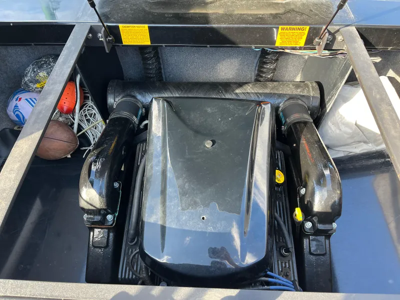 Slide: The Image of 2010 Malibu 21 vRide engine compartment with sports equipment stored nearby. - 9