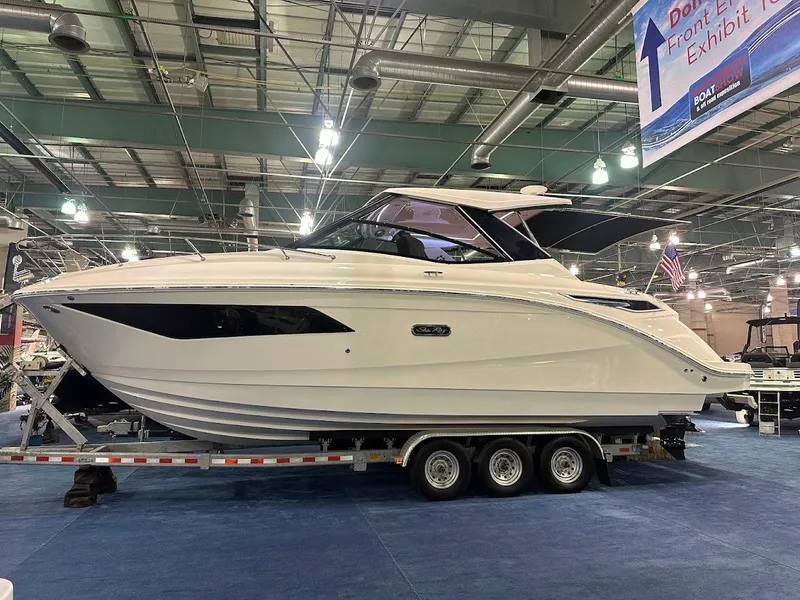 Slide: The Image of 2025 Sea Ray Sundancer 320 yacht displayed indoors on a trailer. - 0