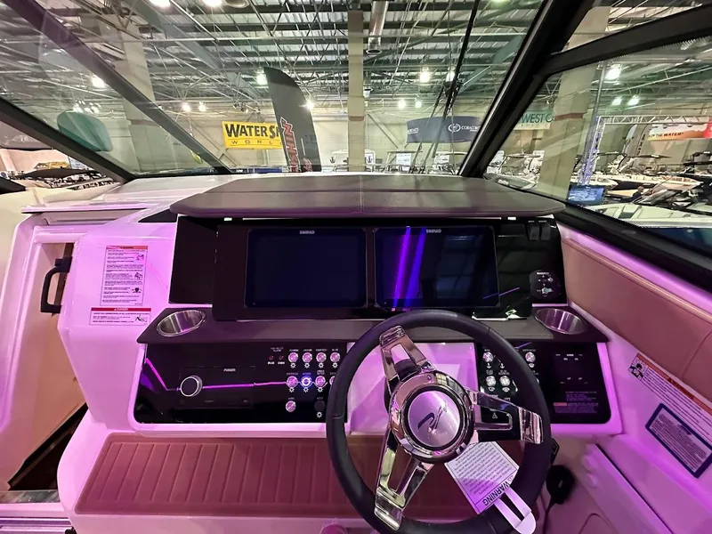 Slide: The Image of 2025 Sea Ray Sundancer 320 helm with modern controls and steering wheel in a showroom. - 14