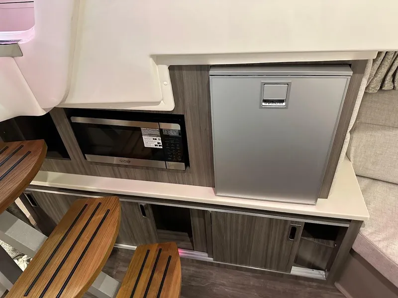 Slide: The Image of Interior of 2025 Sea Ray Sundancer 320 with microwave and compact fridge. - 23
