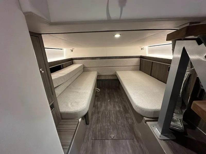 Slide: The Image of 2025 Sea Ray Sundancer 320 cabin interior with modern seating and wood flooring. - 24