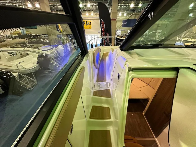 Slide: The Image of 2025 Sea Ray Sundancer 320 interior with modern design and ambient lighting at a boat show. - 29