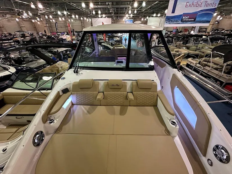 Slide: The Image of 2025 Sea Ray Sundancer 320 interior at a boat show, showcasing luxurious seating and design. - 31