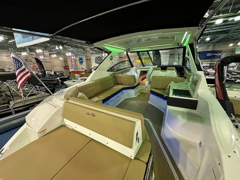 Slide: The Image of 2025 Sea Ray Sundancer 320 interior with tan seating, modern design, and ambient lighting. - 5