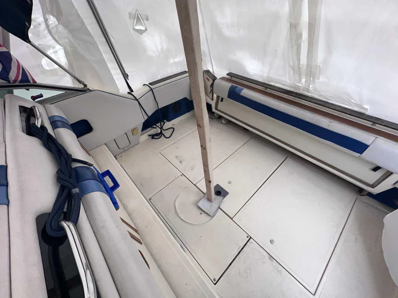 Slide: The Image of 1987 Sea Ray 270 Sundancer interior with white and blue seating, covered deck area. - 1