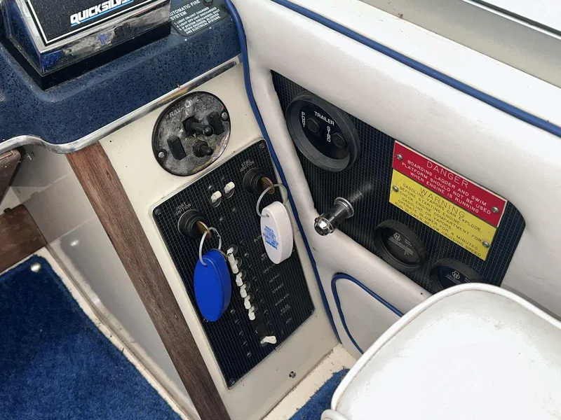 Slide: The Image of 1987 Sea Ray 270 Sundancer dashboard with controls, keys, and warning label. - 11