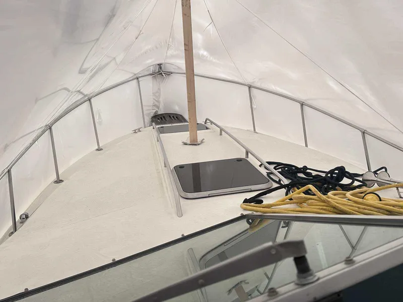 Slide: The Image of 1987 Sea Ray 270 Sundancer boat deck with ropes and hatch, covered in white tarp. - 13