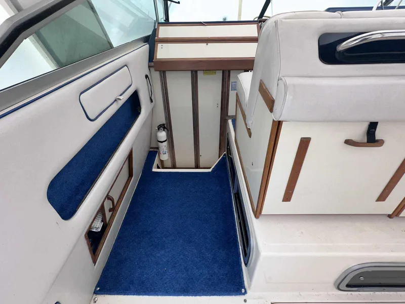 Slide: The Image of Interior of 1987 Sea Ray 270 Sundancer boat with blue carpet and white seating. - 14