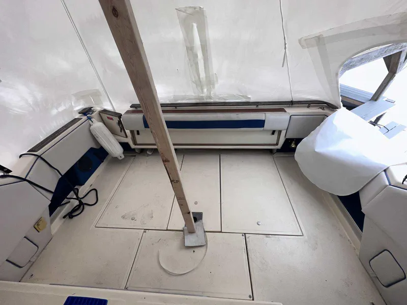 Slide: The Image of 1987 Sea Ray 270 Sundancer interior with white seating and wooden support pole. - 2