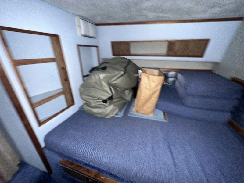 Slide: The Image of Interior cabin of 1987 Sea Ray 270 Sundancer with blue bedding and storage items. - 27