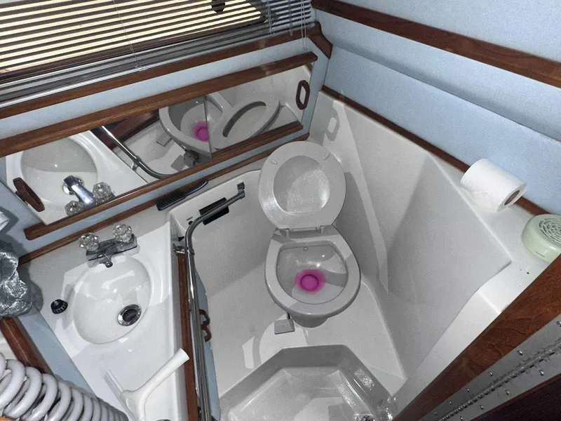 Slide: The Image of 1987 Sea Ray 270 Sundancer bathroom with toilet, sink, and mirror. - 28