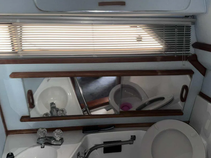 Slide: The Image of 1987 Sea Ray 270 Sundancer bathroom with sink, mirror, and toilet. - 29