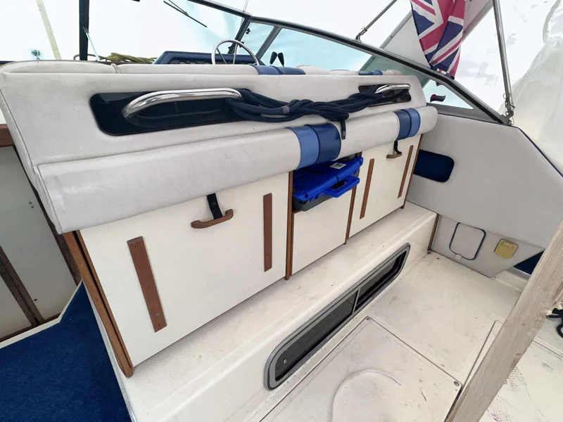 Slide: The Image of 1987 Sea Ray 270 Sundancer interior with storage compartments and nautical decor. - 5