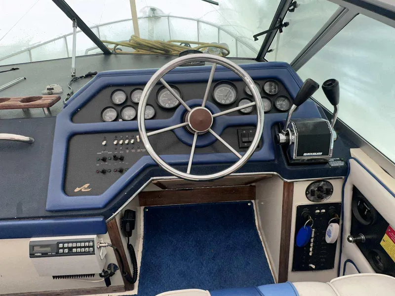 Slide: The Image of 1987 Sea Ray 270 Sundancer helm with steering wheel, gauges, and controls. - 7
