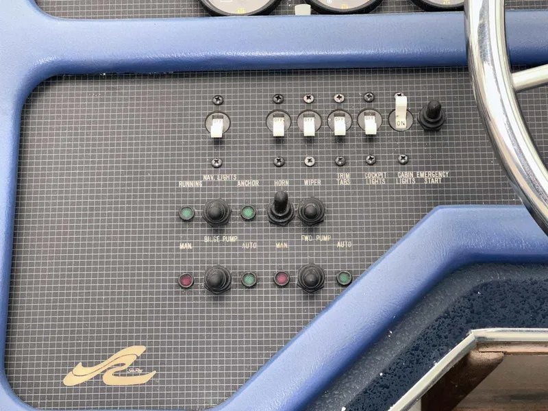 Slide: The Image of Control panel of a 1987 Sea Ray 270 Sundancer boat with switches and buttons. - 9