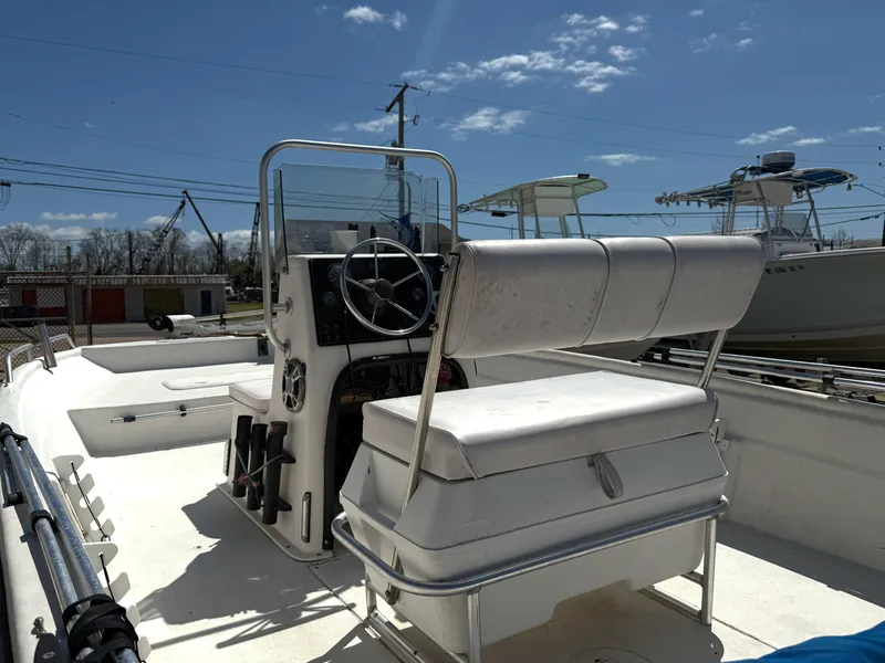 Slide: The Image of 2005 Sea Chaser 1950 RG boat interior with steering wheel and seating under a clear sky. - 2