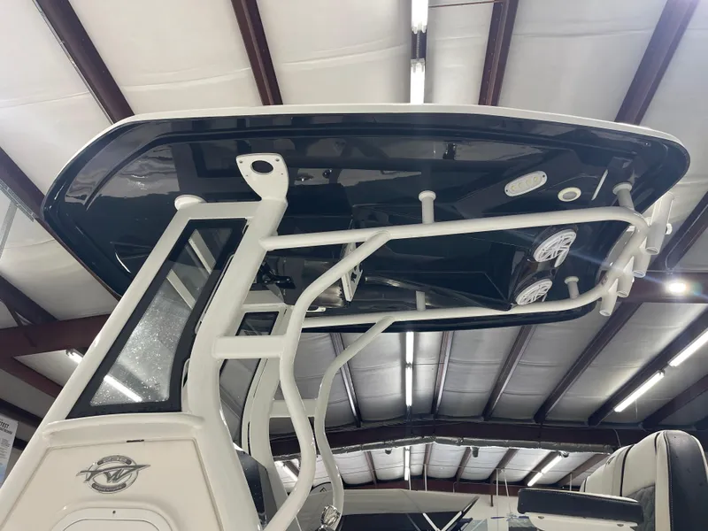 Slide: The Image of 2023 Tidewater 232cc boat interior with T-top and speakers in a showroom. - 10