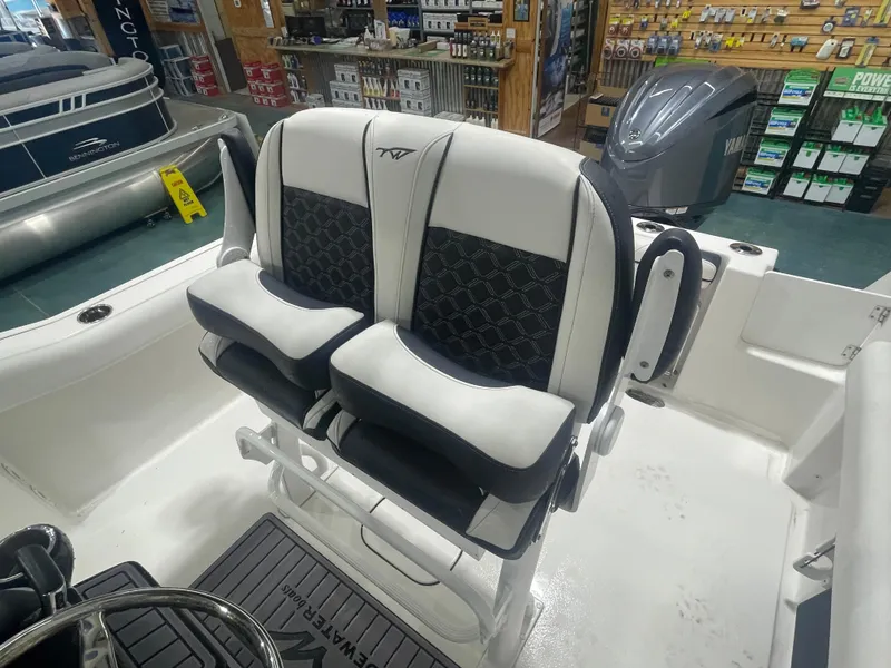 Slide: The Image of 2023 Tidewater 232cc boat interior with dual cushioned seats and Yamaha engine in showroom. - 14