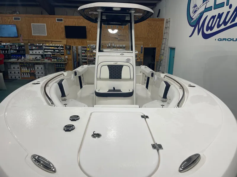 Slide: The Image of 2023 Tidewater 232cc boat interior in showroom, featuring seating and storage compartments. - 9