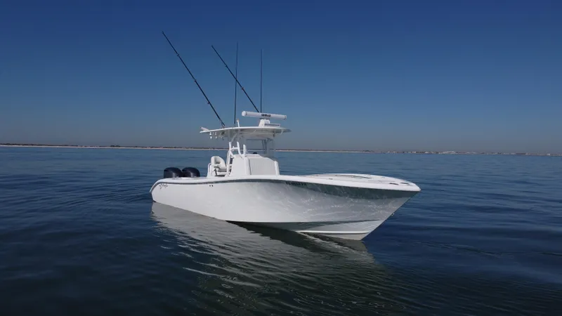 Slide: The Image of 2014 Yellowfin 32 Offshore boat on calm water under clear blue sky. - 1