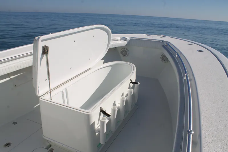 Slide: The Image of 2014 Yellowfin 32 Offshore boat with open storage compartment on calm ocean. - 12