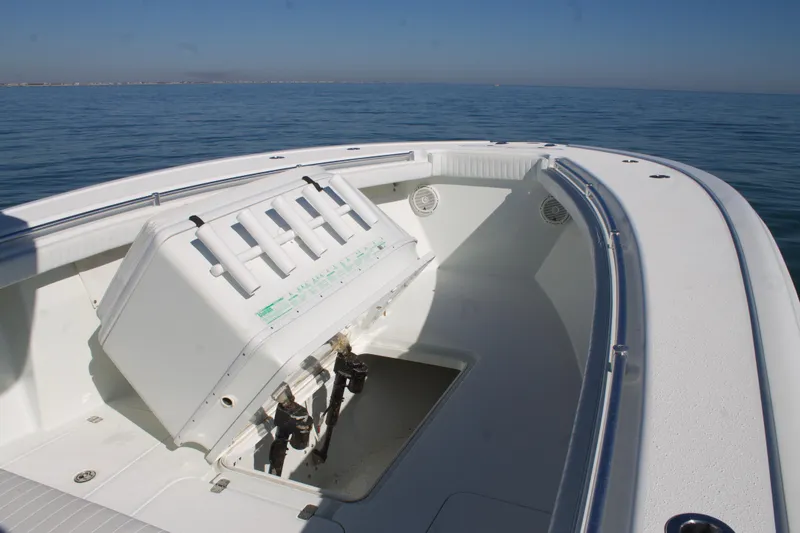 Slide: The Image of 2014 Yellowfin 32 Offshore boat with open storage compartment on calm ocean. - 13