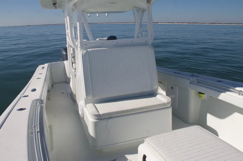 Slide: The Image of 2014 Yellowfin 32 Offshore boat interior with seating, on calm ocean waters. - 15