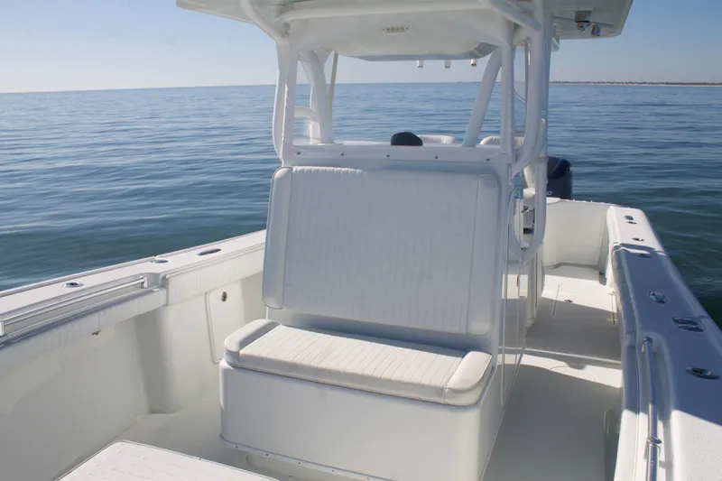 Slide: The Image of 2014 Yellowfin 32 Offshore boat on calm ocean waters, showcasing spacious deck and seating. - 16