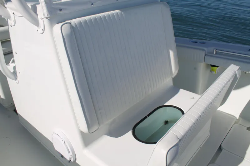 Slide: The Image of 2014 Yellowfin 32 Offshore boat seating and storage area, featuring white cushioned seats. - 17