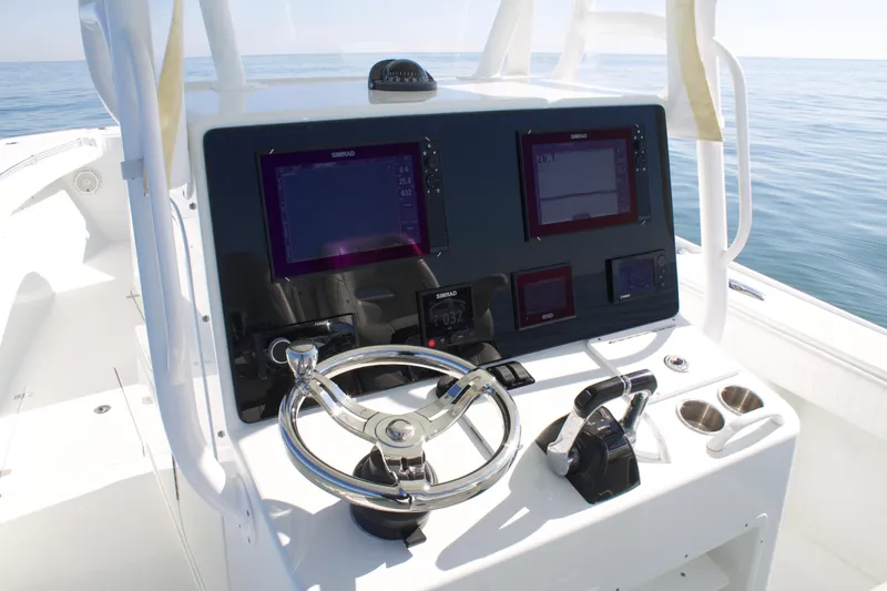 Slide: The Image of 2014 Yellowfin 32 Offshore boat console with steering wheel and navigation screens. - 21