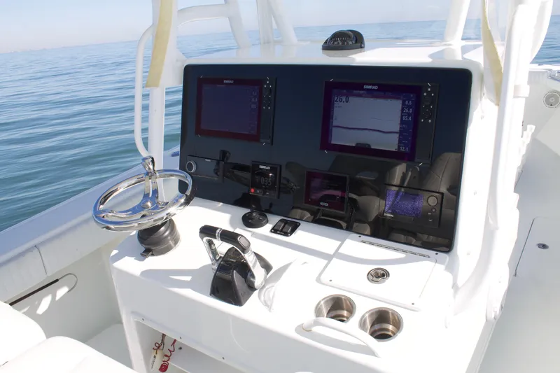 Slide: The Image of 2014 Yellowfin 32 Offshore boat dashboard with navigation screens and steering wheel. - 22