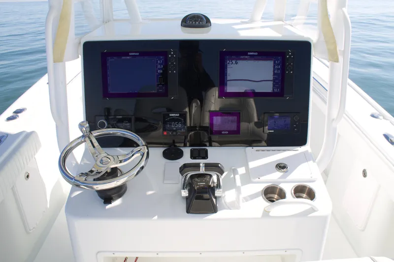 Slide: The Image of 2014 Yellowfin 32 Offshore boat console with steering wheel and navigation screens. - 24