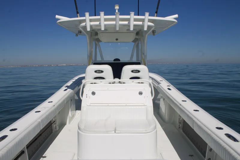 Slide: The Image of 2014 Yellowfin 32 Offshore boat on calm sea, featuring spacious deck and seating. - 34