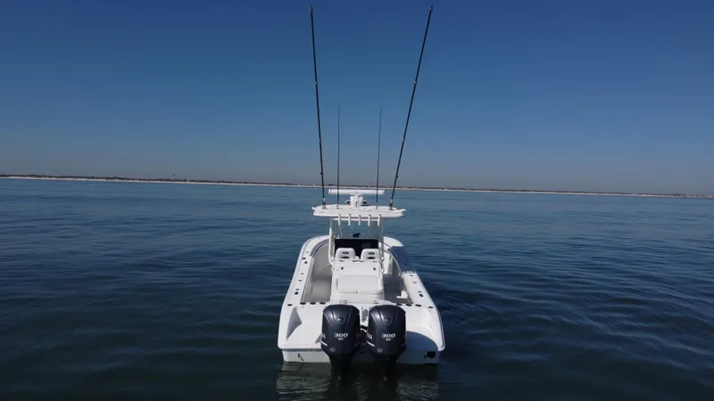 Slide: The Image of 2014 Yellowfin 32 Offshore boat on calm water, rear view with dual engines. - 4