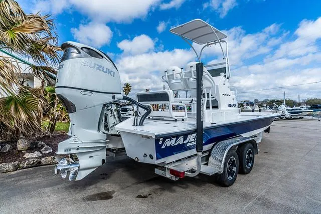 Slide: The Image of 2025 Majek 24 Reaper boat with Suzuki engine on trailer, parked outdoors. - 3