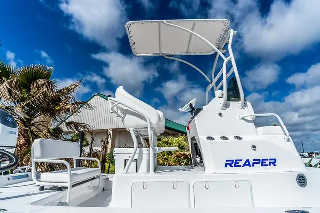 Slide: The Image of 2025 Majek 24 Reaper boat with T-top, white seating, and clear blue sky background. - 5