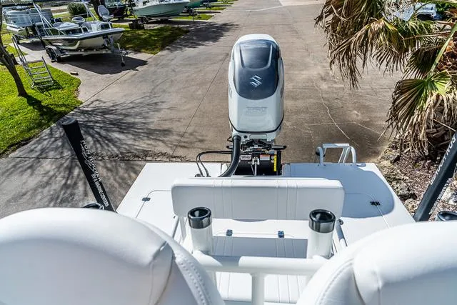 Slide: The Image of 2025 Majek 24 Reaper boat with Suzuki outboard motor, parked near palm trees. - 7