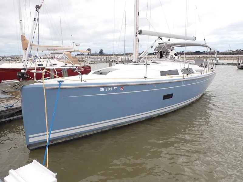 Slide: The Image of 2018 Hanse 348 sailboat docked in marina, featuring sleek blue hull design. - 2